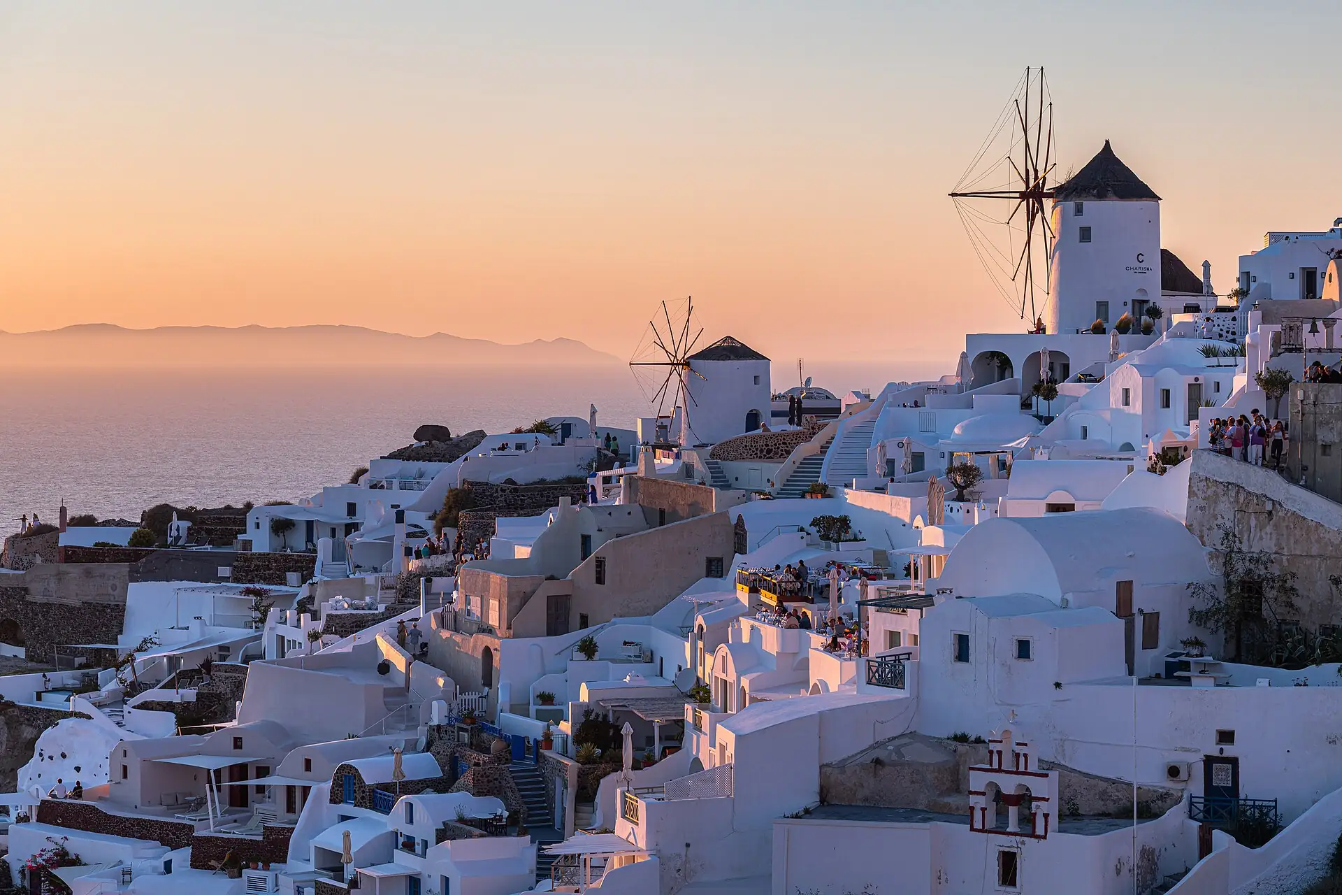 A windmill above the white houses of Oia at dusk