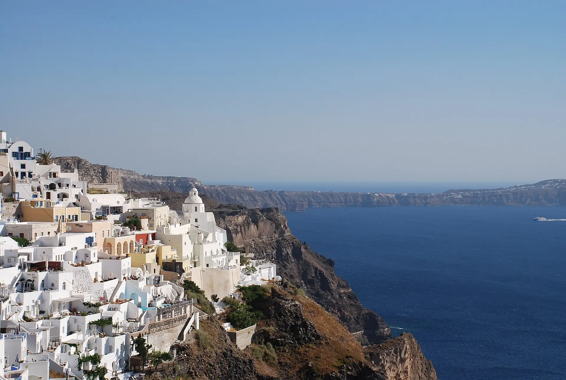 White buildings on the caldera cliff above the blue sea