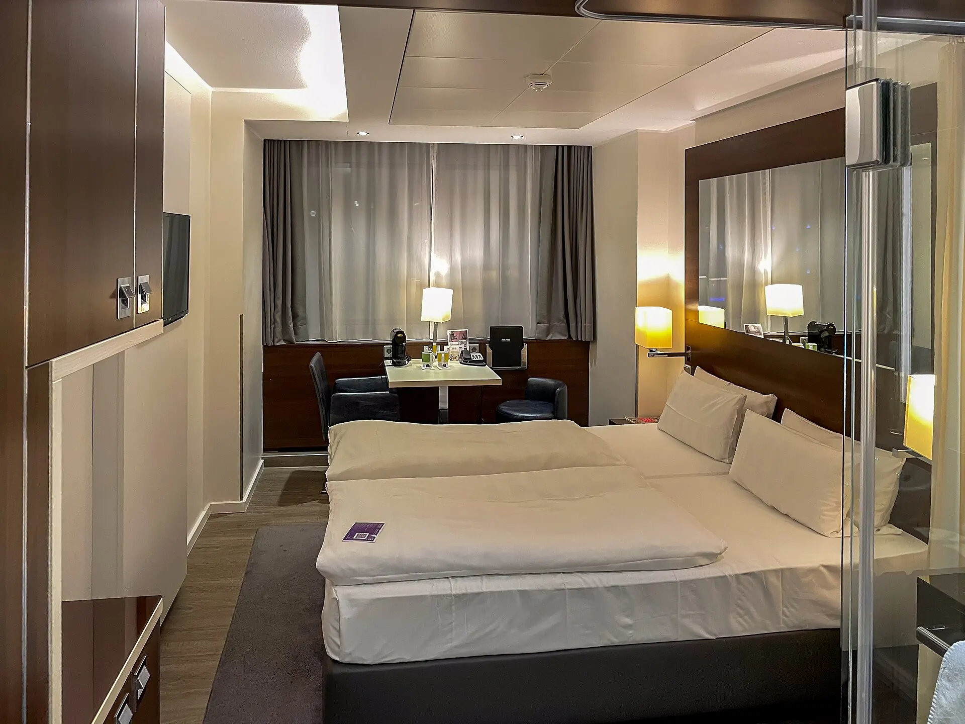 A hotel room with a bed and a window view